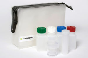 The Travel Kit with Bag includes a clear pouch holding four small bottles with colored caps and a clear jar in front.