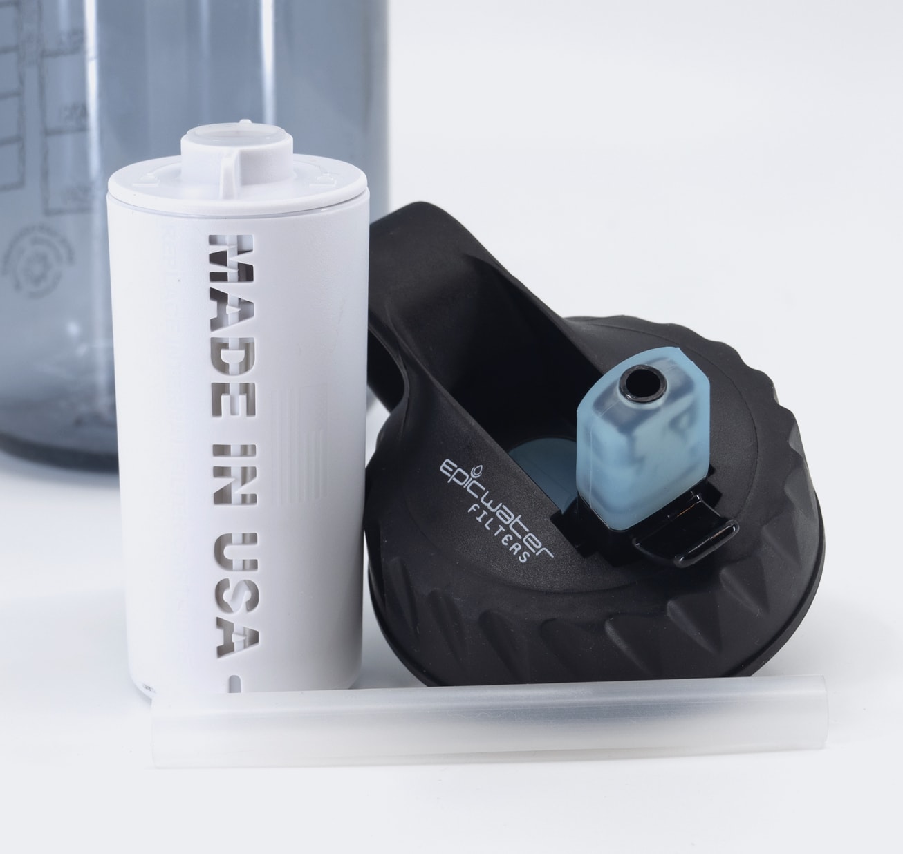Water bottle cap, filter, and straw, with "MADE IN USA" text visible on the white filter.