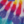 Abstract pattern with overlapping purple, red, yellow, and blue shapes on a light background.