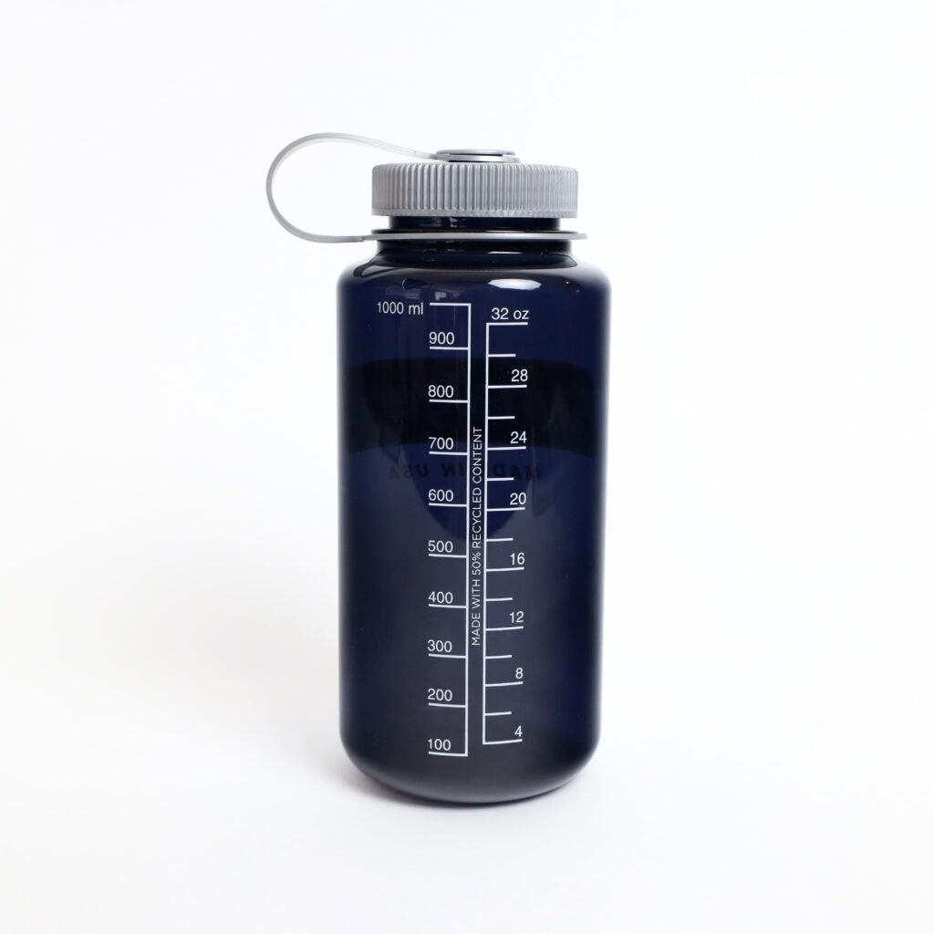 The 32oz Wide Mouth Large Logo bottle features a dark body, gray lid, and a measurement scale in milliliters and ounces on the side.