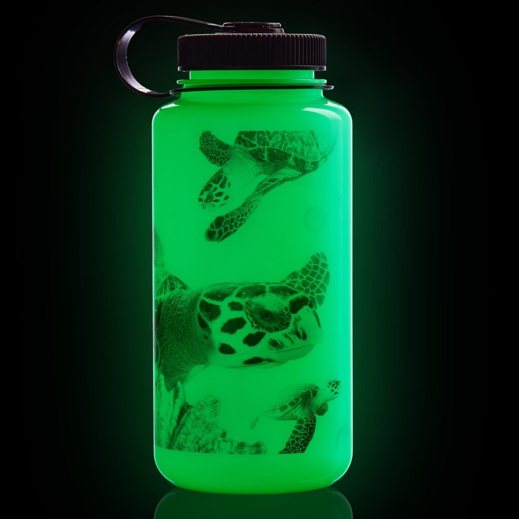 A glowing green water bottle decorated with images of sea turtles on a black background.